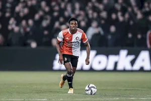 Dynamic Athlete Tyrell Malacia In Orange And White Uniform Wallpaper