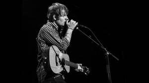 Ed Sheeran Strumming Away In Front Of A Live Audience Wallpaper
