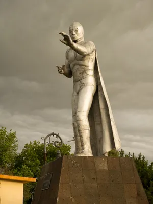 El Santo Statue Under Stormy Skies Wallpaper