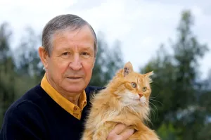 Elderly Manwith Orange Cat Wallpaper