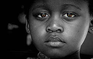 Emotive Portrait Of A Black Girl With Sad Eyes Wallpaper
