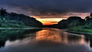 Enjoy Peaceful Serenity Along A Jungle River At Sunset Wallpaper
