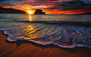 Enjoy The View Of A Dreamy Beach Sunset Wallpaper