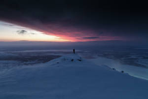 Enjoying Freedom And Beauty Of A Glowing Sunset From A Snowy Mountain Wallpaper