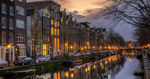 Evening Lights By Amsterdam Canal Wallpaper