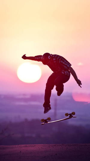 Exciting Mid-air Skateboard Stunt On Iphone Wallpaper Wallpaper