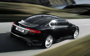 Experience Speed And Luxury With The Black Jaguar Car Wallpaper