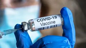 Female Doctor Holding Covid-19 Vaccine Wallpaper