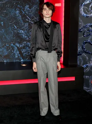 Finn Wolfhard With Gray Pants Wallpaper