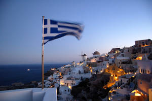 Flag Of Greece Waving At Pole At Santorino, Greece Wallpaper