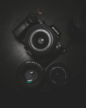 Flat Lay Photography Of Black Sony Dslr Camera On Black Surface Wallpaper