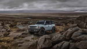 Ford Bronco In Vast Deserted Field Wallpaper