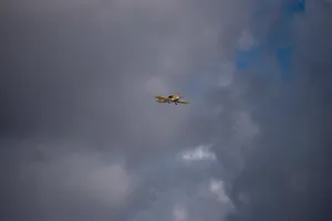 Freedom In The Sky: Small Yellow Plane Soaring High Wallpaper