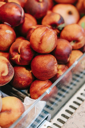 Fresh Nectarines Displayed In A Supermarket Fruit Section Wallpaper