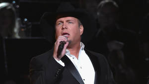 Garth Brooks Holding A Microphone Wallpaper