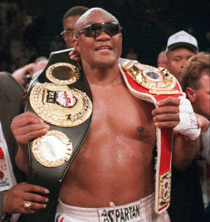 George Foreman With Championship Belts Wallpaper