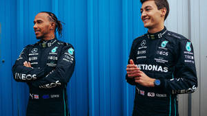 George Russell And Lewis Hamilton Sharing A Moment Of Joy On The F1 Track Wallpaper