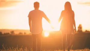 Girlfriend And Boyfriend Holding Hands During Sunset Wallpaper