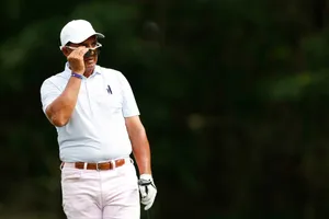 Golfer Adjusting Sunglasseson Course Wallpaper