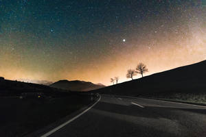 Gray Asphalt Road Near Silhouette Of Mountain At Night Time Wallpaper