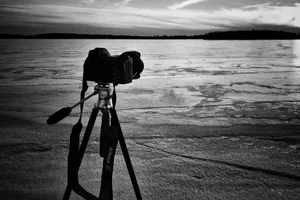 Grayscale Photo Of Camera Near Sea Wallpaper