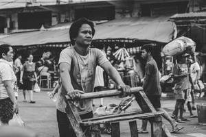 Greyscale Photography Of Man Pushing Cart Wallpaper