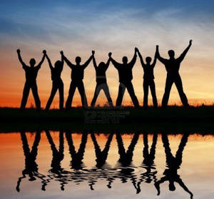 Group Raising Hands At Sunset Wallpaper