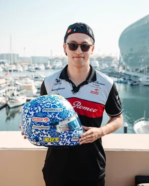 Guanyu Zhou Holding His Race Helmet Wallpaper