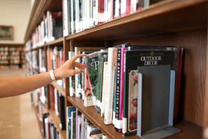 Hand Reaching To A Reference Book Wallpaper