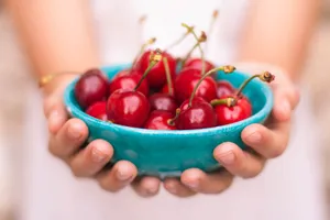 Hands Holding Bowl Of Cherries Wallpaper