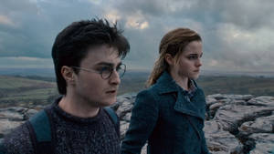 Hermione Granger And Harry Potter Face Off In A Magical Duel. Wallpaper