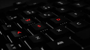 High-end Gaming Laptop With Red-labeled Wasd Keyboard Wallpaper