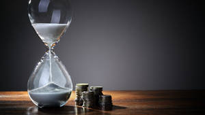 Hourglass With Coin Stacks Tiempo Background Wallpaper