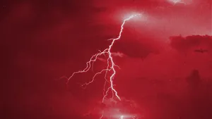 Illuminating The Night Sky With Red Lightning Wallpaper