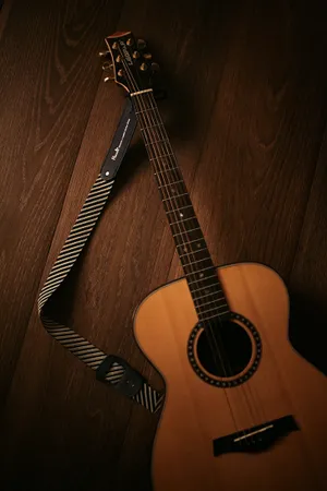 Intricately Crafted Acoustic Guitar With Striped Strap Wallpaper