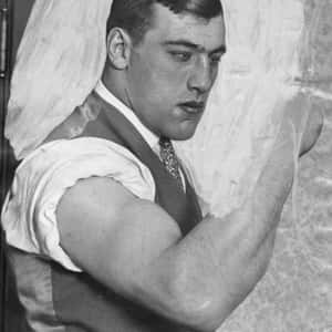 Italian Professional Boxer Primo Carnera Flexing His Biceps Wallpaper