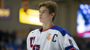 Jack Hughes In Action During A Hockey Match Wallpaper