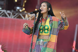 Jhené Aiko Striking A Pose In A Blue Outfit Wallpaper