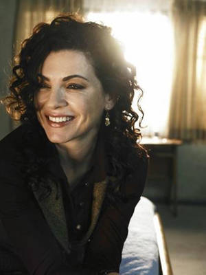Julianna Margulies Grinning In Her Black Curls Wallpaper