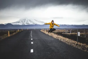 Jump Shot Photo Of Man Over Road And Mountain Alps At Distance Wallpaper