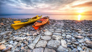 Kayaking Along The Rocky Shoreline Wallpaper