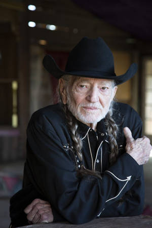 Legendary Musician Willie Nelson In Classic Black Attire Wallpaper