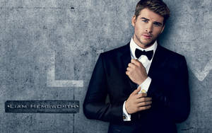 Liam Hemsworth Leaning On Blue Wall Wallpaper