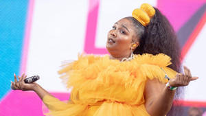 Lizzo In Yellow Frilly Outfit Wallpaper