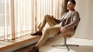 Luke Evans Sitting On Chair Wallpaper
