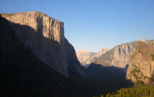 Macbook On A Wooden Desk Wallpaper