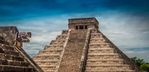 Majestic Chichen Itza Under The Cloudy Blue Sky Wallpaper