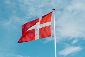 Majestic Flag Of Denmark Against The Sky Wallpaper
