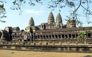 Majestic Stone Ruins Of Angkor Thom Against A Clear Blue Sky Wallpaper