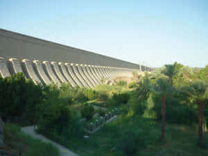 Majestic View Of Aswan High Dam With Green Garden Wallpaper
